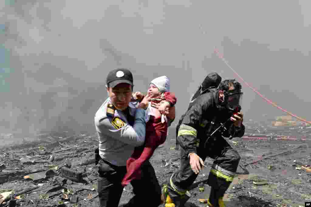 아제르바이잔 수도 바크의 아파트 화재 현장에서 경관이 아기를 구출하고 있다. 화재로 16명이 숨지고, 50여명이 다쳤다.