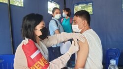 Petugas Kesehatan Polda Sulawesi Sulawesi Tengah saat memberikan vaksinasi COvid-19 bagi warga Kota Palu di Taman GOR, Kota Palu. Jumat (4/6/2021). (Foto: VOA/Yoanes Litha)