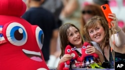 Phryge, la mascota de los Juegos Olímpicos de París 2024, posa para una selfie con fanáticos antes de un partido de fútbol femenino, el 28 de julio de 2024, en Niza, Francia.