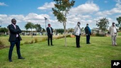 Family and friends observe social distancing during the funeral for Benedict Somi Vilakasi at the Nasrec Memorial Park outside Johannesburg, April 16, 2020. South Africa is under a five-week lockdown in a effort to fight the coronavirus pandemic.