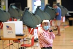 지난 6월 예비선거(프라이머리)가 열린 미국 텍사스주 휴스턴의 투표소에서 선거 진행 도우미가 신종 코로나바이러스 감염증(COVID-19)를 막기 위해 보호장비를 착용하고 있다.