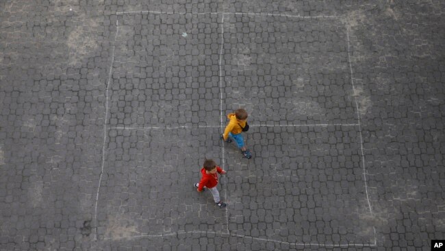 Ukrainian refugee children walk along the backyard of the Lauder Morasha Jewish school in Warsaw, Poland, Thursday, July 28, 2022. (AP Photo/Michal Dyjuk)