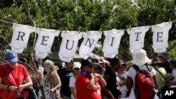 Protesters use baby cloths to display a message during an immigration really across from the federal courthouse in Brownsville, Texas, June 28, 2018.