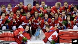 Team Canada gathers for a group photo after beating the USA 3-2 in overtime of the gold medal women's ice hockey game at the 2014 Winter Olympics, Feb. 19, 2014, in Sochi, Russia.