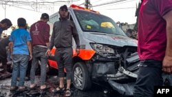 Orang-orang berkumpul di sekitar ambulans yang rusak akibat serangan Israel yang di depan Rumah Sakit Al-Shifa di Kota Gaza pada 3 November 2023. (Foto: AFP)