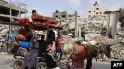 Una familia palestina se traslada con sus pertenencias a Beit Lahia, en el norte de la Franja de Gaza, el 19 de mayo de 2024, en medio del conflicto en curso entre Israel y el grupo militante Hamás.