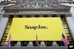 FILE - A banner for Snap Inc. hangs from the front of the New York Stock Exchange, in New York, March 2, 2017.
