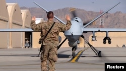 A U.S. airman guides a U.S. Air Force MQ-9 Reaper drone as it taxis to the runway at Kandahar Airfield, Afghanistan March 9, 2016.