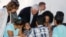 U.S. Vice President Mike Pence leans in as he visits with Venezuelan families at the Calvary Chapel in Cartagena, Colombia, Aug. 14, 2017. 