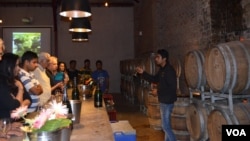 Visitors learn about wine at the tasting room of Sula Vineyards in Nashik, Maharashtra, India. (Anjana Pasricha for VOA)