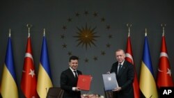 Turkish President Recep Tayyip Erdogan, right, and Ukrainian President Volodymyr Zelenskiy pose for photographs after they signed agreements, in Istanbul, Oct. 16, 2020. 