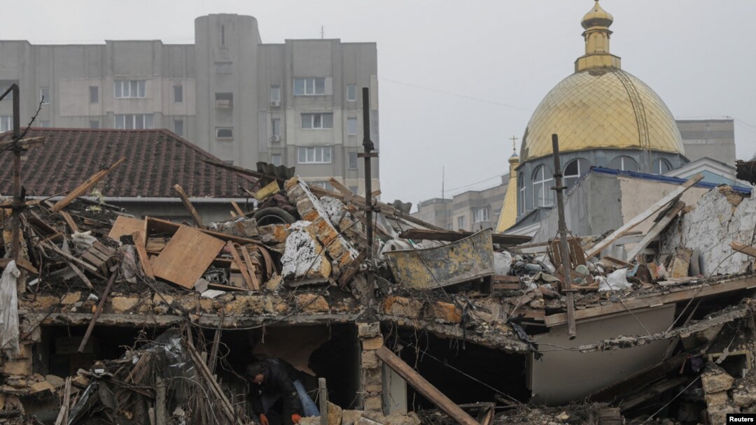 Seorang warga setempat membersihkan puing-puing di lokasi hancurnya bangunan tempat tinggal akibat serangan rudal Rusia di Odesa, Ukraina, 29 Desember 2023. (Foto: REUTERS/Nina Liashonok)