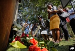 FILE - People lay flowers in honor of the dead outside the gate of the dusitD2 hotel complex which was attacked last week, at a wreath-laying event organized by the hotel complex management in Nairobi, Kenya, Jan. 22, 2019.