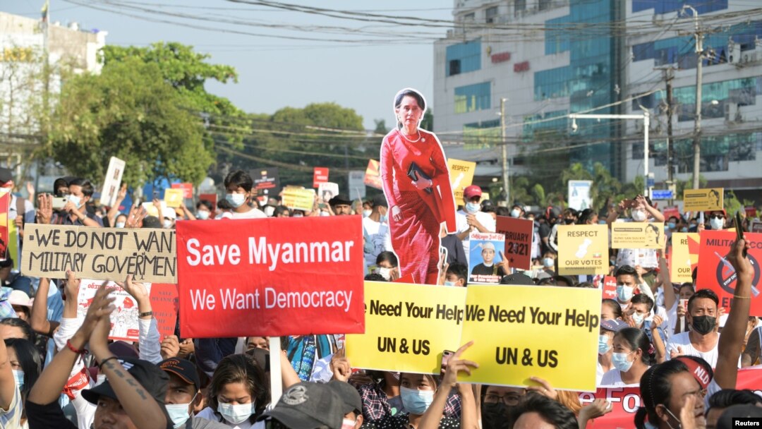 Los manifestantes portan una pancarta con ela imagen de Aung San Suu Kyi, la líder civil depuesta por el golpe militar en Rangún el 1 de febrero de 2021.