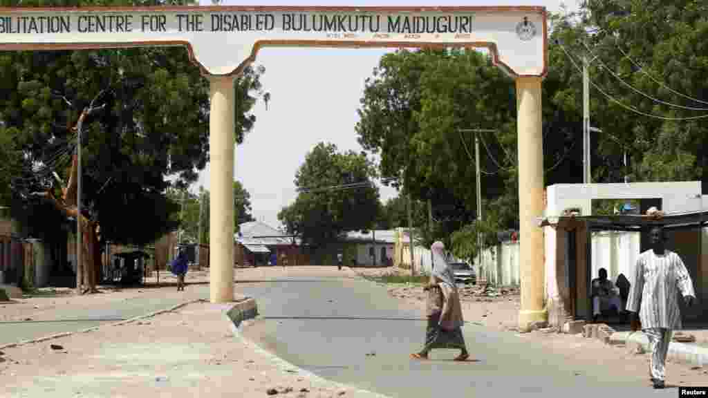 A woman crosses a deserted road in Bulumkutu, after the military declared a 24-hour curfew over large parts of Maiduguri in Borno State May 19, 2013.