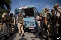 Indian security personnel stand guard near paramilitary soldiers' bus that was damaged in an ambush by suspected rebels in Pampore, on the outskirts of Srinagar, Indian-controlled Kashmir, June 25, 2016.