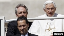 Pelayan Paus, Paolo Gabriele (bawah kiri) tiba bersama Paus Benediktus XVI di Basilika Santo Petrus Vatikan (23/5).