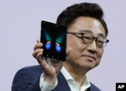 DJ Koh, president and CEO of IT and Mobile Communications, holds up the new Samsung Galaxy Fold smartphone during an event, Feb. 20, 2019, in San Francisco.