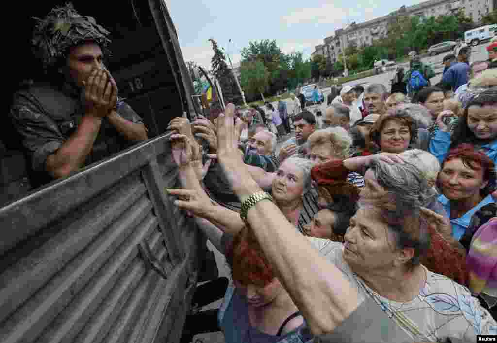 People wait for food aid from Ukrainian soldiers in Slovyansk, July 6, 2014.