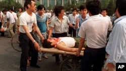 资料照：在中国军队对抗议人群开枪后不久，北京市民把受伤者抬上平板车。(1989年6月4日)
