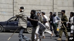 Government backers chase anti-government protesters during clashes in Sanaa, February 14, 2011