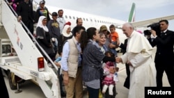 Le pape François accueille un groupe de réfugiés syriens à l'aéroport de Ciampino à Rome, le 16 avril 2016. 