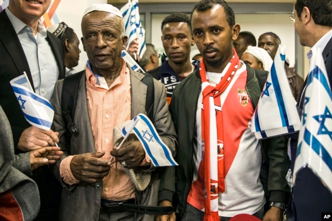 Ethiopian Jews hold Israeli flags at the Ben Gurion airport near Tel Aviv, Israel, Feb. 4, 2019.