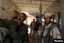 Ảnh tư liệu - Các chiến binh Lực lượng Dân chủ Syria (SDF) đứng bên trong một tòa nhà gần Manbij, ngày 17 tháng 6 năm 2016.