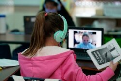 Students at Driggers Elementary School attend a class in-person as they interact with classmates virtually, Monday, Feb. 8, 2021, in San Antonio. (AP Photo/Eric Gay)