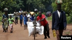 FILE - A Malawian man transports food aid distributed by the United Nations World Food Progamme (WFP) through maize fields in Mzumazi village near the capital Lilongwe, Feb. 3, 2016.