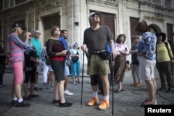 FILE - American tourists look around during a tour at old Havana, Cuba, Dec. 14, 2015.