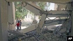 Children climb over the wreckage of a school that Libyan officials say was bombed by NATO forces in the town of Zlitan, east of Tripoli, August 4, 2011