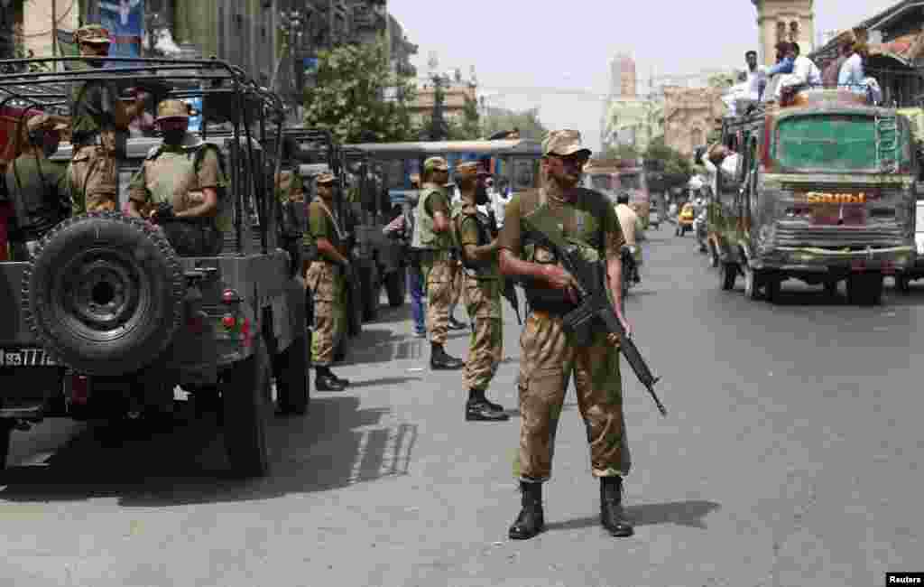 Paramilitary soldiers stand guard along a road outside of the district city court in Karachi, Pakistan, May 10, 2013. 