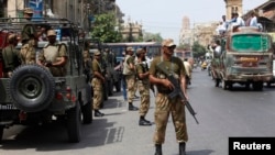 Tentara berjaga sepanjang jalan di luar pengadilan kota Karachi, Pakistan (10/5). Ledakan bom mengguncang Waziristan Utara di malam menjelang Pemilu di negara itu, menewaskan sedikitnya lima orang dan melukai 18 lainnya.