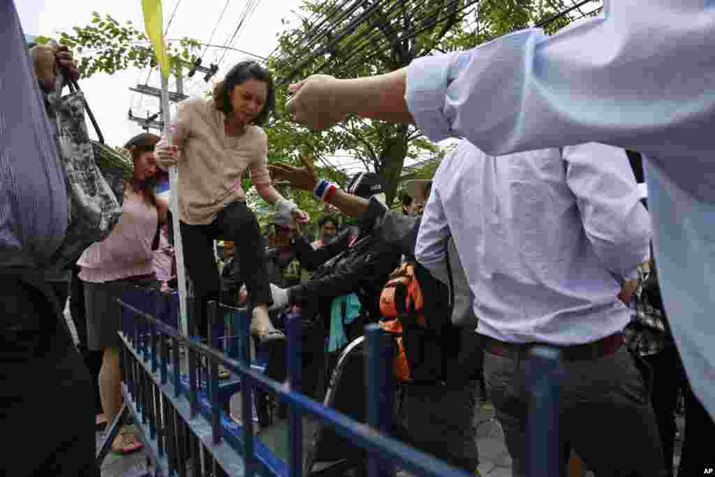 Anti-government protesters surrounding the Thaksin Shinawatra-owned office building let employees leave the property over its gate, Bangkok, Thailand, Feb. 20, 2014.&nbsp;