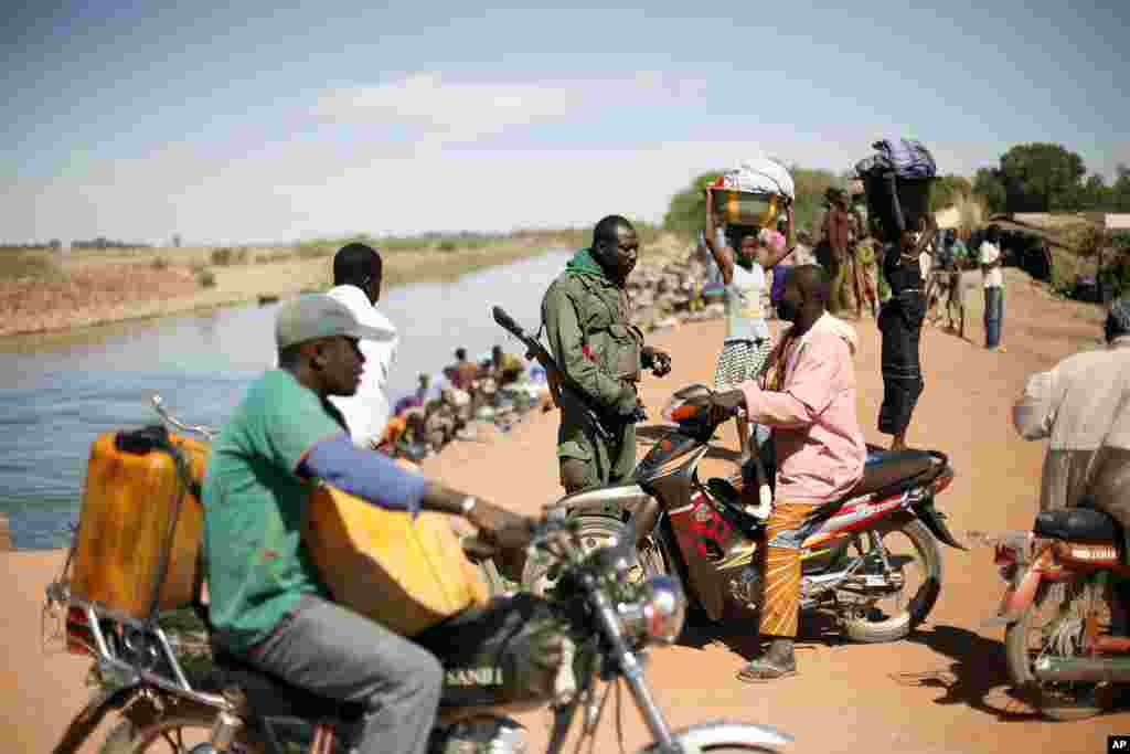 A Malian soldier checks identity papers in the center of Diabaly, Mali, January 21, 2013.