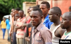 Suspected fighters are paraded before the media by Burundian police after clashes in the capital Bujumbura, Burundi, Dec. 12, 2015.