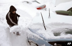 George Salman from Norwood, Massachusetts, digs his car out, Jan. 28, 2015, after a powerful storm hit the northeastern U.S. this week.