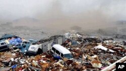 Magari na takataka nyingine zikiwa katika kifusi kilichobebwa na mawimbi ya tsunami kaskazini mwa Japan.