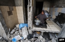 Palestinka kuha obrok u razrušenom domu koji je pogođen u izraelskim napadima.