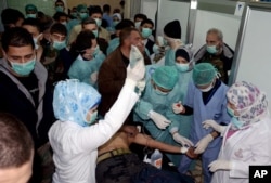 FILE – Doctors treat a Syrian victim who suffered an alleged chemical attack at Khan al-Assal village, March 19, 2013, in this photo released by the Syrian official news agency SANA.