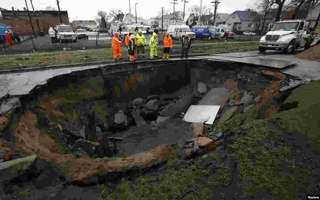 Workers look into a sinkhole caused by a broken water main in Chicago, Illinois, Apr. 18, 2013. 