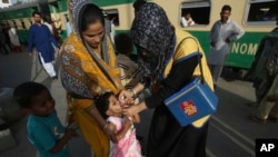 FILE - A Pakistani health worker gives a polio vaccine to a girl at Karachi railway station in Pakistan, April 11, 2018. 