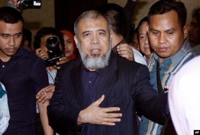 Hakim Mahkamah Konstitusi Patrialis Akbar (tengah) dikawal polisi setelah pembacaan hukuman di pengadilan Tipikor, Jakarta, 4 September 2017.