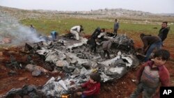 Warga Suriah berkerumun di sekitar reruntuhan helikopter yang ditembak jatuh di Alepo, 14 Februari 2020. 