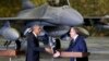 With an F-16 fighter in the background, U.S. President Barack Obama and Poland's President Bronislaw Komorowski (R) shake hands upon Obama's arrival at Chopin Airport in Warsaw, June 3, 2014.