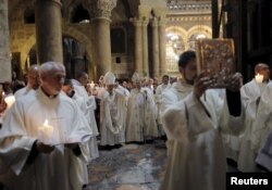 Latin Patriarch of Jerusalem Fouad Twal, center, takes part in the Easter procession in the Church of the Holy Sepulchre in Jerusalem's Old City, April 5, 2015.