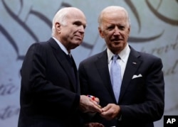 FILE - Sen. John McCain, R-Ariz., receives the Liberty Medal from former Vice President Joe Biden, chairman of the National Constitution Center's Board of Trustees, in Philadelphia, Oct. 16, 2017.