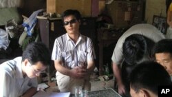 ນາຍ Chen Guangcheng (ກາງ) ນັກເຄຶ່ອນໄຫວຕາບອດ ແລະເພື່ອນນັກເຄຶ່ອນໄຫວດ້ວຍກັນ ທີ່ໝູ່ບ້ານແຫ່ງນຶ່ງ ໃນຈີນ