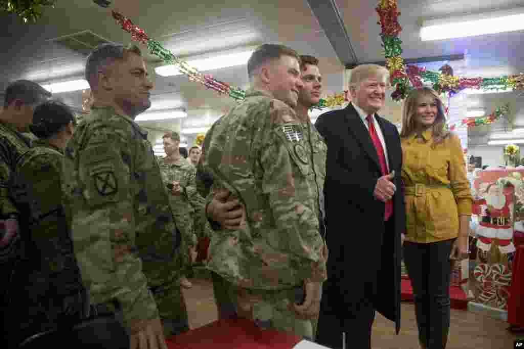 El presidente Donald Trump y la primera dama Melania Trump posan para una fotografía mientras visitan a los militares en un comedor en la base aérea de Al Asad, Irak, el miércoles 26 de diciembre de 2018. 